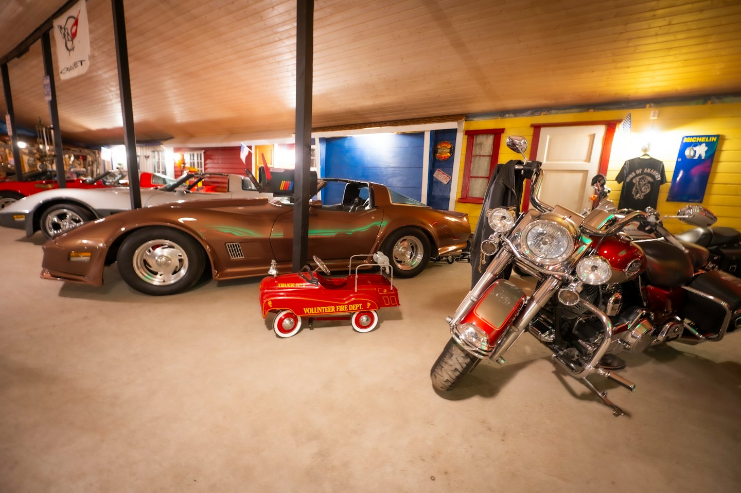 Oldtimer und ein Motorrad in einer dekorierten Garage.